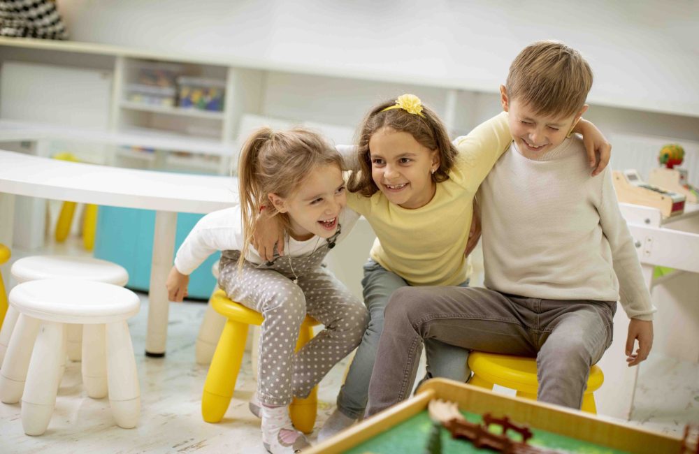 Group of cute kindergarten kid friends sitting and having fun